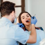 dentist-making-professional-teeth-cleaning-withb-cotton-female-young-patient-dental-office-min
